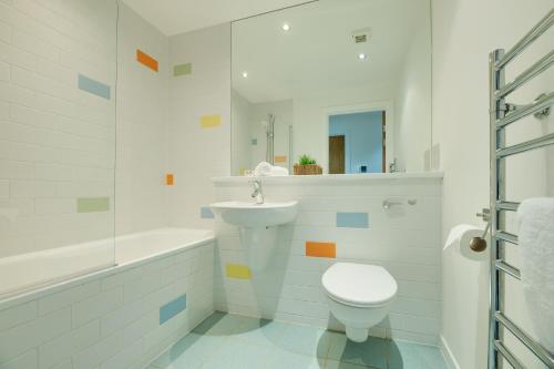uma casa de banho branca com um WC e um lavatório em All Saints Apartments 606 by Week2Week em Newcastle upon Tyne