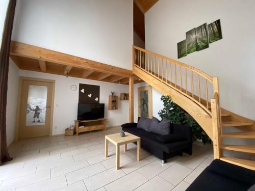 a living room with a staircase and a couch at Ferienhaus Plattenstein in Untermitterdorf