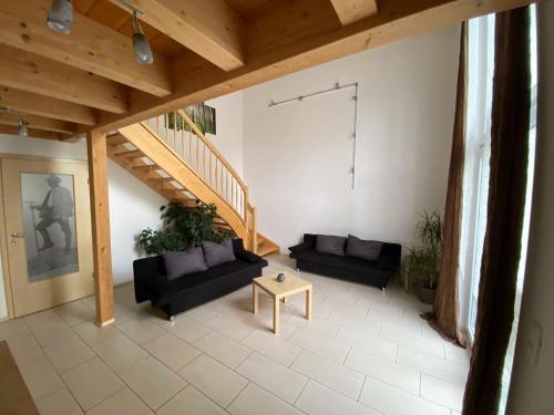 a living room with two couches and a staircase at Ferienhaus Plattenstein in Untermitterdorf