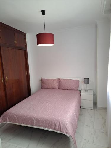 sypialnia z łóżkiem z różowym kocem w obiekcie APARTAMENTO SAN ANDRÉS TORRE DEL MAR w mieście Torre del Mar