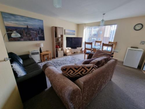 a living room with a couch and a tv at Moonbay apartment in Cardiff