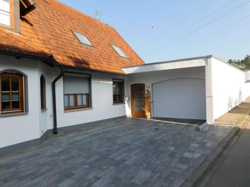 a white house with a garage and an orange roof at Trudis Ferienwohnung in Veringendorf