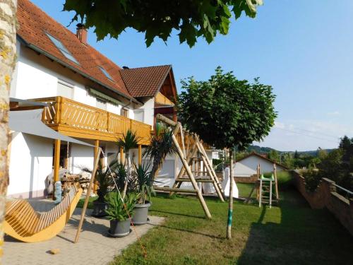 a house with a playground in the yard at Trudis Ferienwohnung in Veringendorf