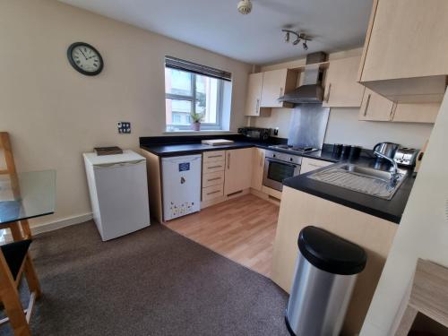 a kitchen with white appliances and a counter top at Moonbay apartment in Cardiff