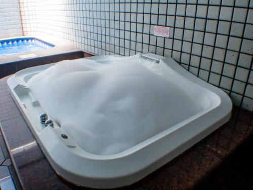 a bath tub in a bathroom with a tiled wall at Cartago Hotel in Rio de Janeiro