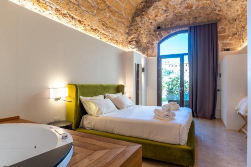 um quarto com uma cama e uma banheira num quarto em Bastione Spasimo Boutique Hotel em Palermo