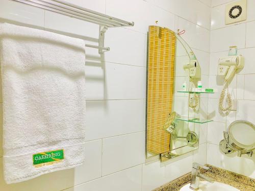 baño con lavabo, espejo y toalla en Oakspring Hotel and Luxury Suites, en Lagos