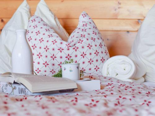 Una cama con almohadas, un libro y una botella. en Rifugio en Lienz