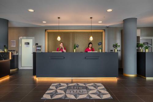 two women standing behind a counter in a lobby at the niu Ridge in Halle an der Saale