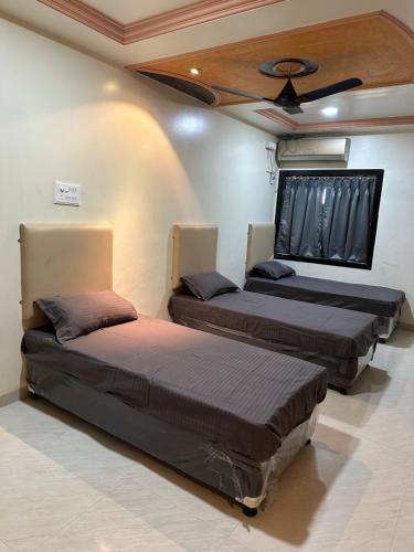 twee bedden in een kamer met een plafond bij Beyond Stays in Pune