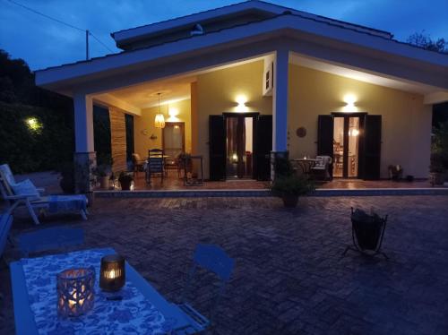 a house with a patio at night at Casa Mimosa Holiday Room in Sperlonga