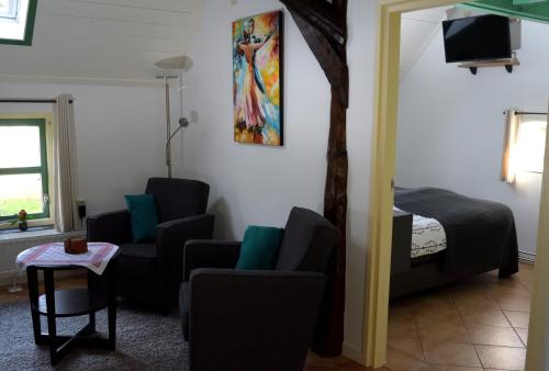 sala de estar con 2 sillas y 1 cama en De Corylus Vakantie Appartement, en Oosterhesselen
