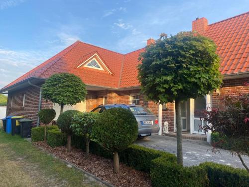 um carro estacionado em frente a uma casa com um telhado laranja em BlüteNo1 mit Sauna, Kamin und Garten em Wiesmoor