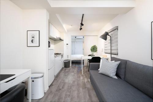 a living room with a couch and a kitchen at Home Sweet Office Heiwajima in Tokyo