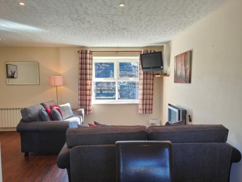 a living room with two couches and a tv at Holiday Cottage 7 in Watermillock
