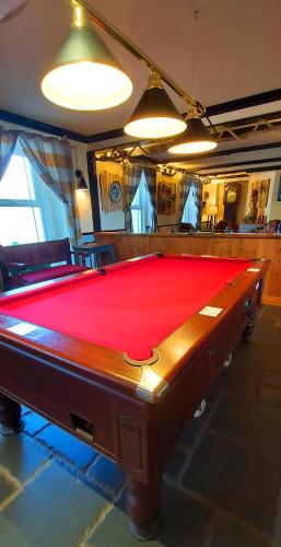 a pool table in a room with a red cloth at Sportsmans Valley Hotel in Liskeard