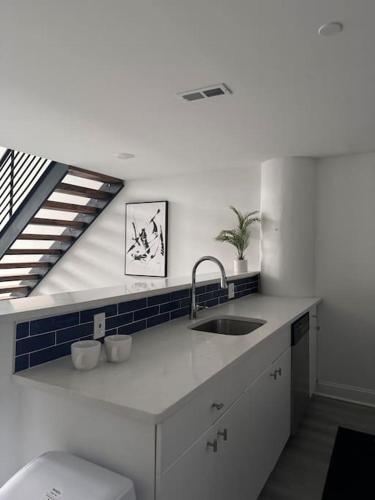 een witte keuken met een wastafel en een trap bij MEB Loft in Darby