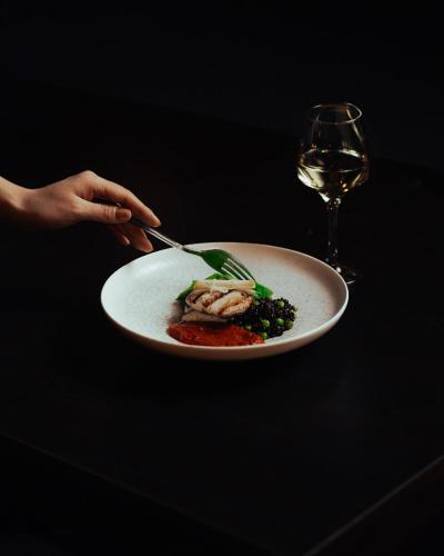 a person holding a plate of food and a glass of wine at Cappadocia Cave Suites Adult Only in Goreme