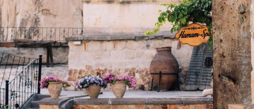 a group of potted plants sitting next to a building at Cappadocia Cave Suites Adult Only in Goreme