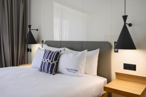 a bedroom with a bed with white sheets and pillows at Nevo by Isrotel Collection in Ein Bokek