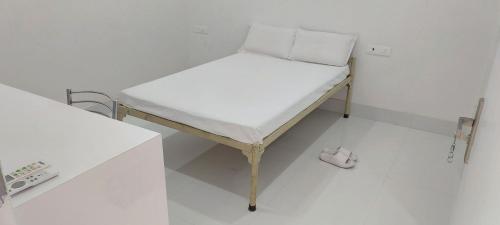 a small bed in a room with a white floor at Planet Star Homestay in Bikaner