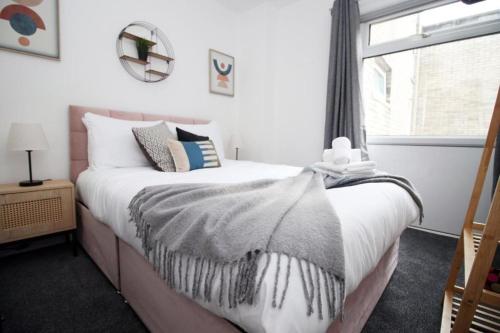 a bedroom with a bed with a large window at Peaceful 3 Bed Flat with Parking and Balcony by CTO Serviced Apartments in Cardiff
