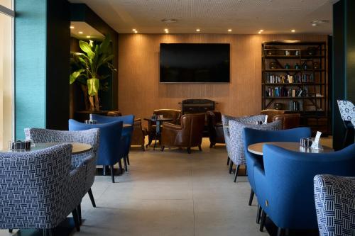 a restaurant with blue chairs and tables and a tv at Catalonia Majórica in Palma de Mallorca