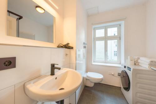 ein weißes Bad mit einem Waschbecken und einem WC in der Unterkunft Design Apartments Potsdam West in Potsdam