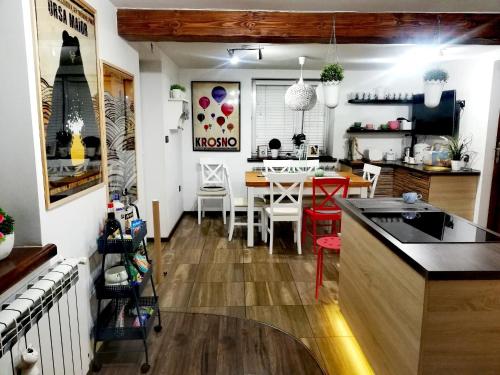 a kitchen and dining room with a table and chairs at Pokoje goscinne u Olguni in Chyrowa