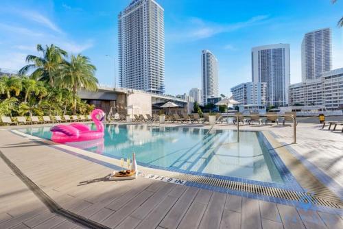 a large swimming pool with a city skyline in the background at Infinite Views, Amazing Pool, Gym, Near Beach in Hallandale Beach
