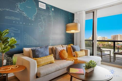 a living room with a couch and a map on the wall at Infinite Views, Amazing Pool, Gym, Near Beach in Hallandale Beach
