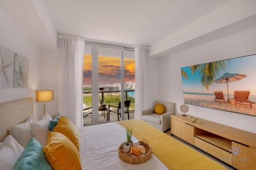 Un dormitorio con una cama con vistas a la playa. en Infinite Views, Amazing Pool, Gym, Near Beach, en Hallandale Beach