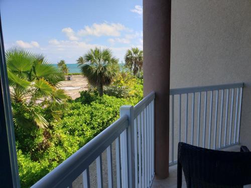 a balcony with a view of a beach and palm trees at Holiday Inn Resort Grand Cayman by IHG in George Town