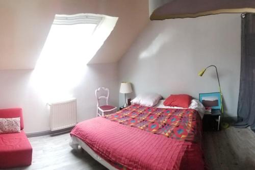 a bedroom with a large bed and a red chair at La Halte Ligerienne in Saint-Gervais-la-Forêt