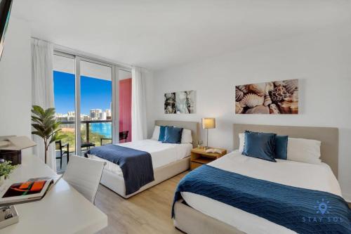 a bedroom with two beds and a view of the city at Infinite Views Amazing Pool Gym in Hallandale Beach