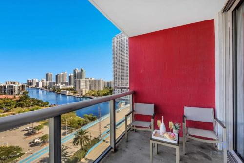 a balcony with two chairs and a red wall at Infinite Views Amazing Pool Gym in Hallandale Beach