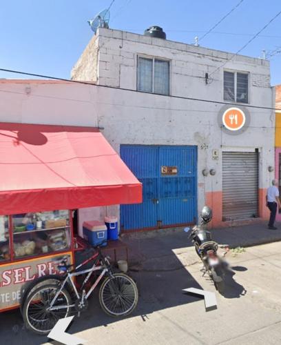 uma bicicleta estacionada ao lado de um edifício com um telhado vermelho em Pedro Montoya Zona Centro em San Luis Potosí