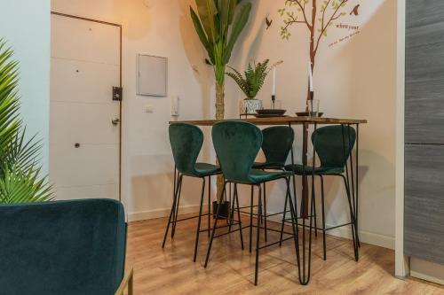 a dining room with a table and green chairs at tuGuest Cetti Meriem Apartment in Granada
