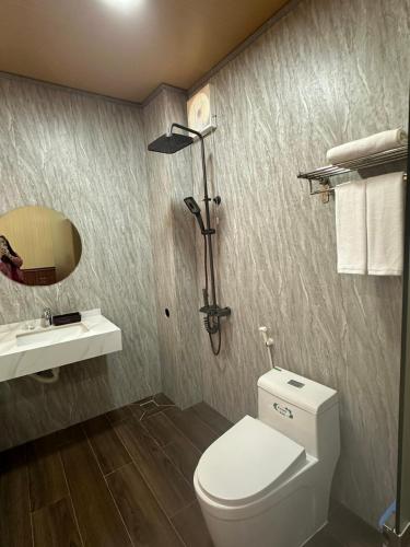 a bathroom with a white toilet and a sink at Dream House Homestay in Thuận Biên