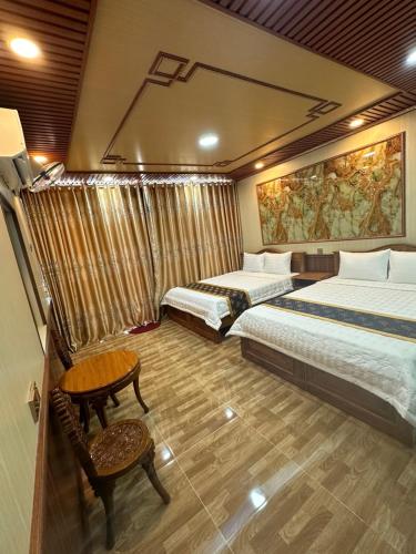 a hotel room with two beds and a table at Dream House Homestay in Thuận Biên