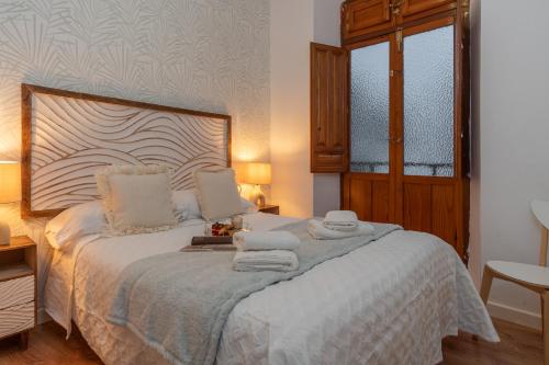 1 dormitorio con 1 cama con toallas en tuGuest Cetti Meriem Apartment, en Granada