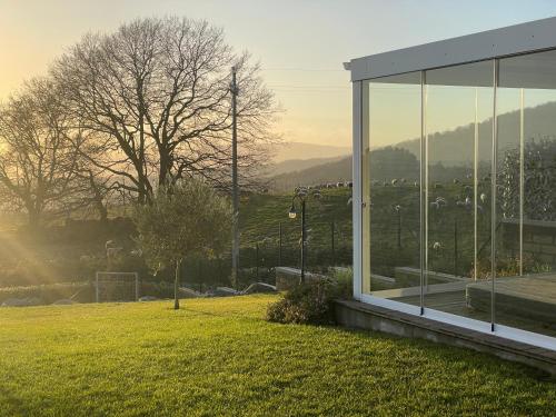a glass building in a field with a herd of cows at VILLA "Lago Blu" vista lago di Bracciano, con vasca idromassaggio esterna in Trevignano Romano