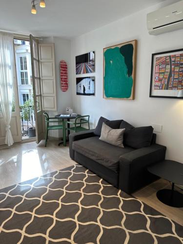 ein Wohnzimmer mit einem Sofa und einem Tisch in der Unterkunft Studio Arts Soho - Malaga in Málaga