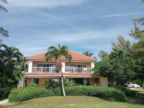 a house with a palm tree in front of it at Oceanview at Coral Habour in Nassau