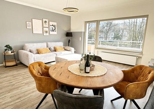 ein Wohnzimmer mit einem Tisch, Stühlen und einem Sofa in der Unterkunft Exklusive Wohnung mit Ahrblick 2, Balkon und 2 Schlafzimmer in Bad Neuenahr-Ahrweiler