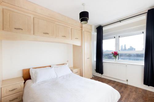 a bedroom with a white bed and a window at 2 bed Bethnal Green Penthouse in London