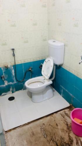 a bathroom with a white toilet in a room at Inpalace guest house in Gwalior