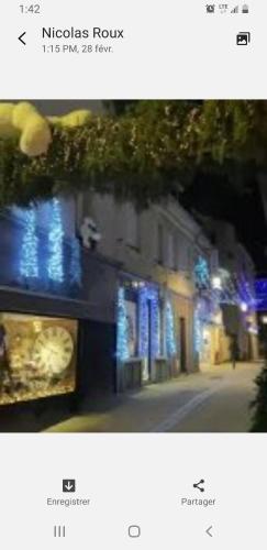 a picture of a building with blue lights on a street at La Brionnaise Chambre in Brionne