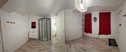a large bathroom with a mirror and red curtains at La Brionnaise Chambre in Brionne