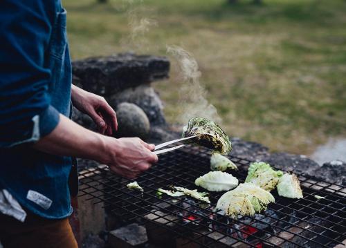a person is cooking food on a grill at Hotel Stelor in Västergarn